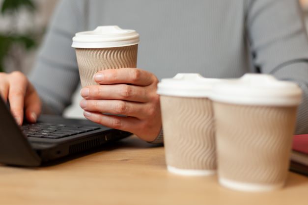 コーヒーを持つ女性とパソコン